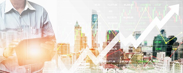 Businessman standing with tablet real estate investing graphic