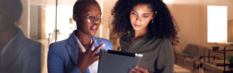 Two Female Professionals In Office Hallway