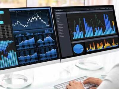 Professional reviewing screens showing bar graphs and maps