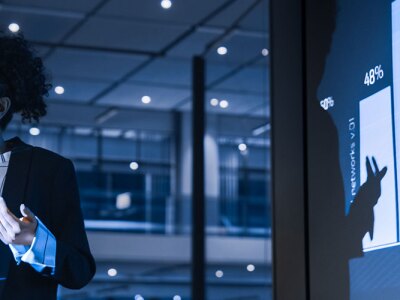 Innovative businesswoman showcasing analytics at a marketing meeting.