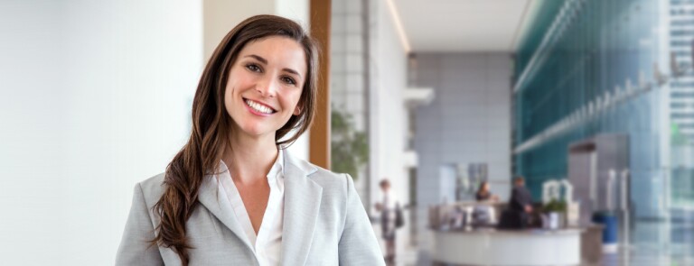 Friendly professional stands in atrium of university