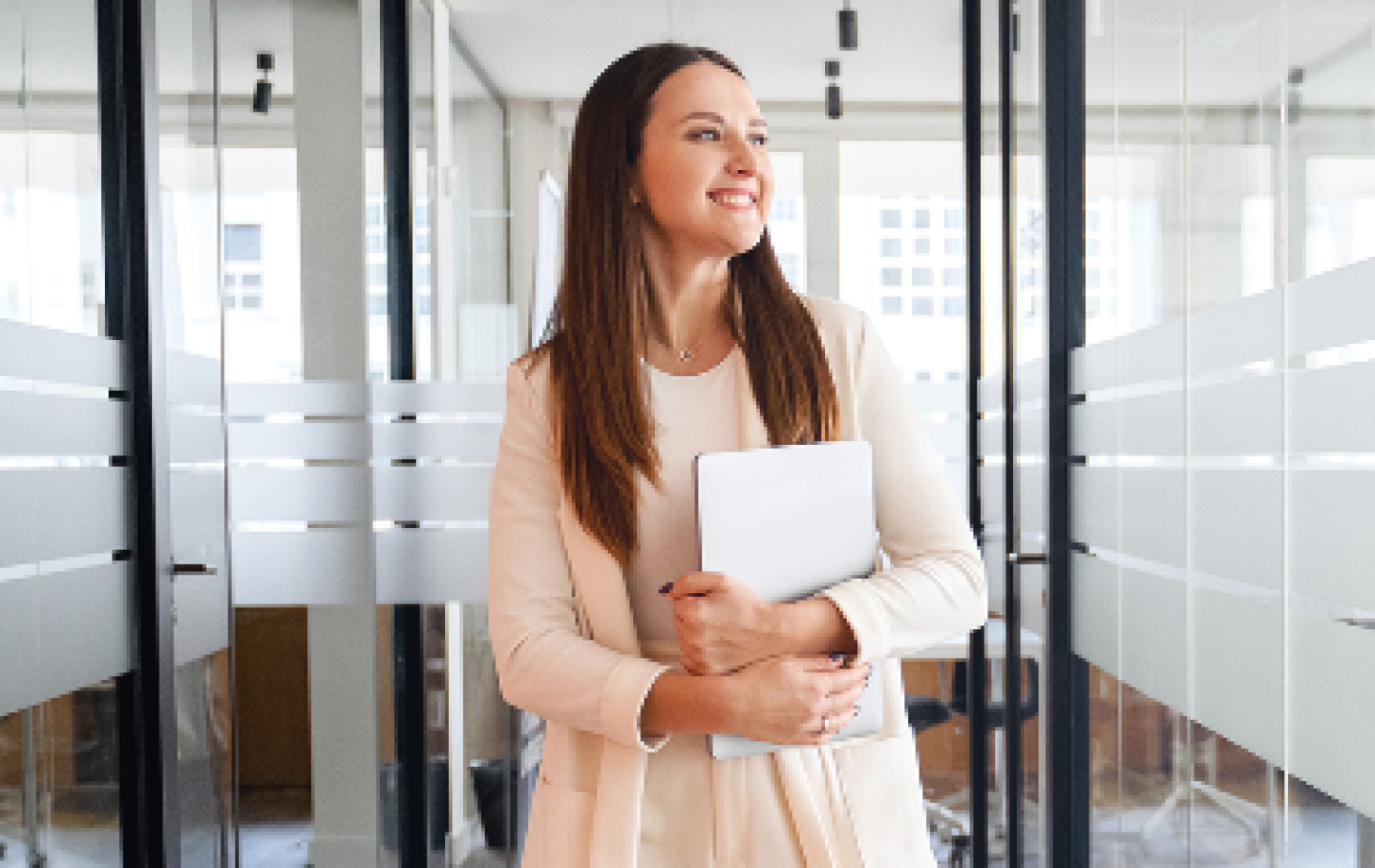 woman smiling walking down the hall of an office buidling