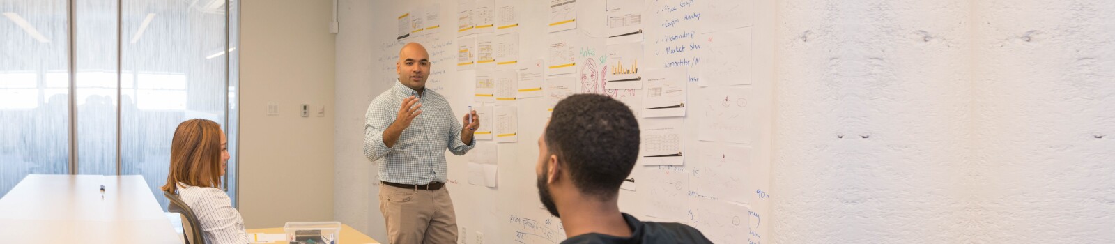 IMC students working through a product market strategy on a white board