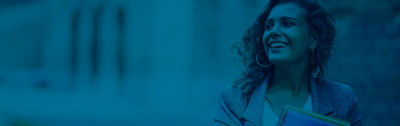 Young female business professional smiles while holding paper folders.
