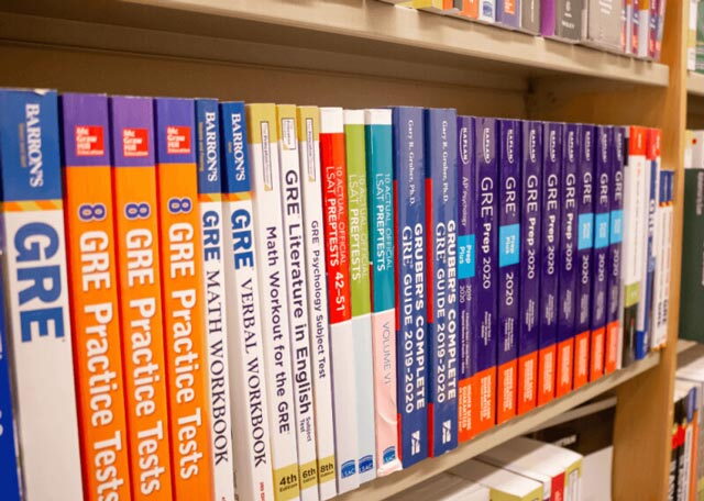 Shelf of GRE prep workbooks on a shelf