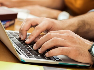 Young man in class working on his laptop
