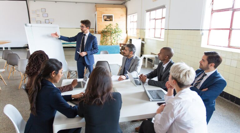 Man in suit giving presentation to a group
