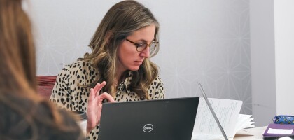 Group of women working together around a table with laptop