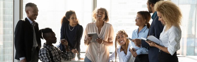 Friendly mixed-race team gather in office workplace for informal briefing.