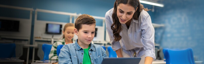 Special education teach giving individual attention to a young student.