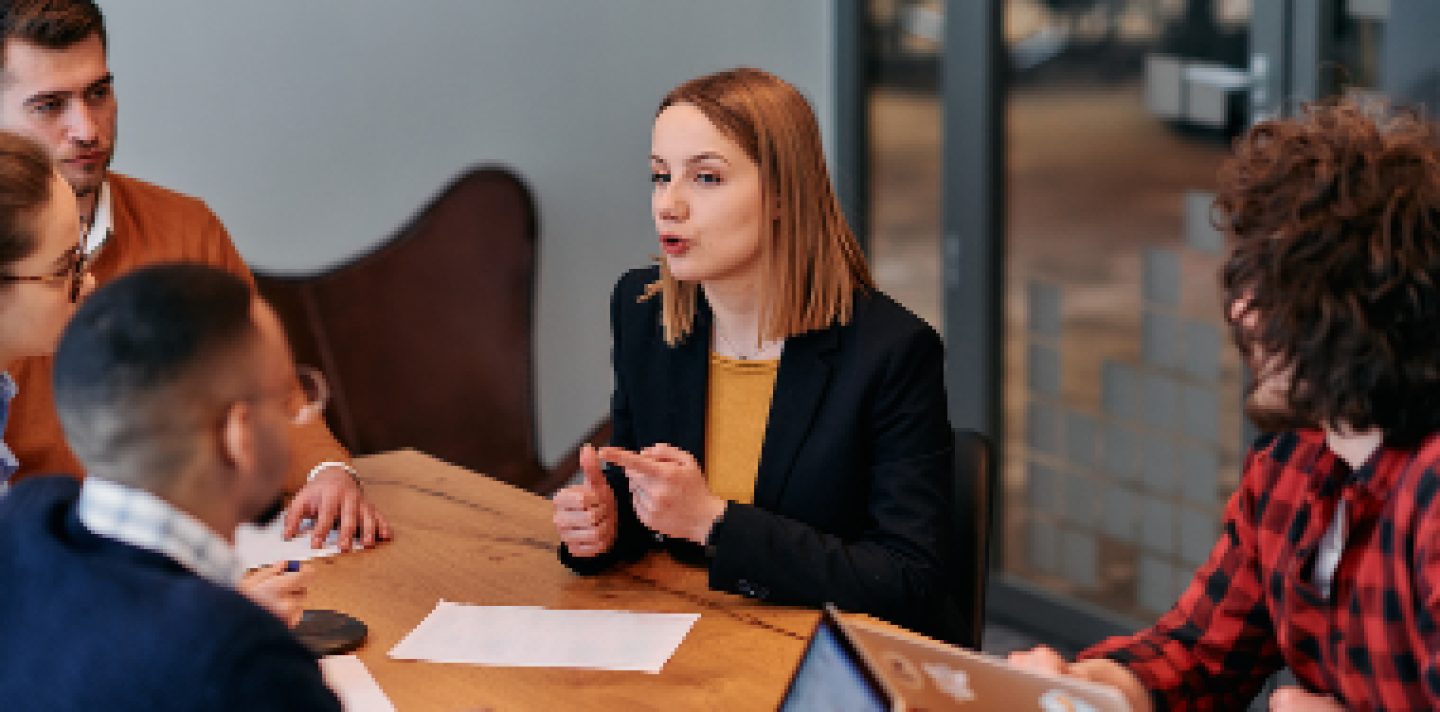 lady having a speaking with her team in an office
