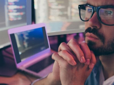 Male professional reviews code on screen