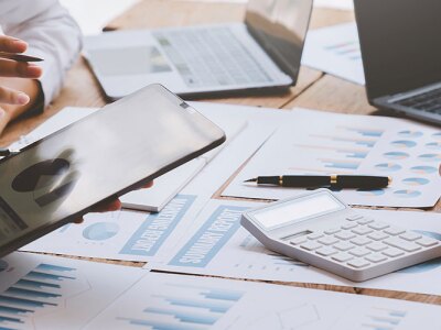 A financial analyst analyzes a business financial report on a digital tablet during a discussion.