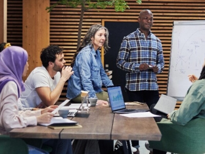 Diverse group of coworkers in a meeting discussing a chart