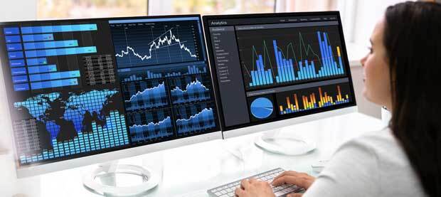 Professional reviewing screens showing bar graphs and maps