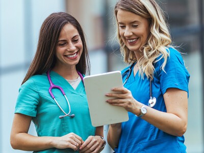 Two nurses reviewing patient information on a tablet