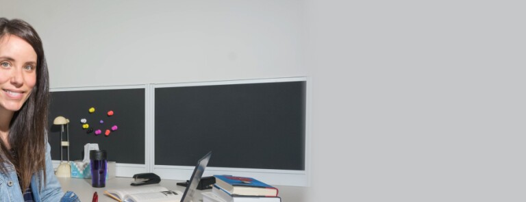 IMC Part Time student sits at desk while working on a laptop