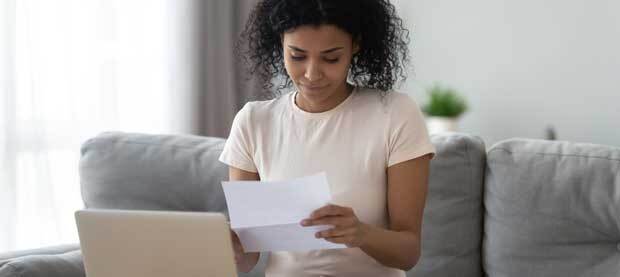 woman on sofa looking at MBA paperwork