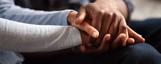 Two individuals holding hands