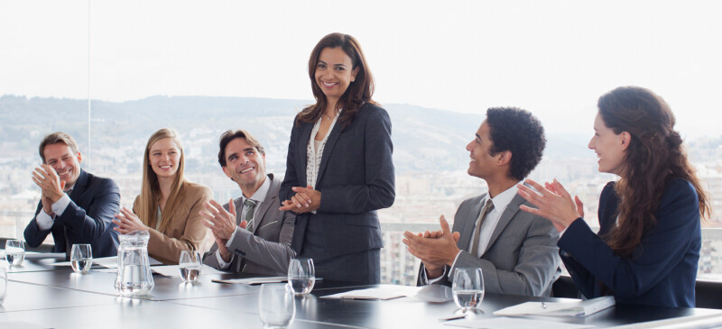 Five Professionals Standing In Group In A Hallway Dark Clothes