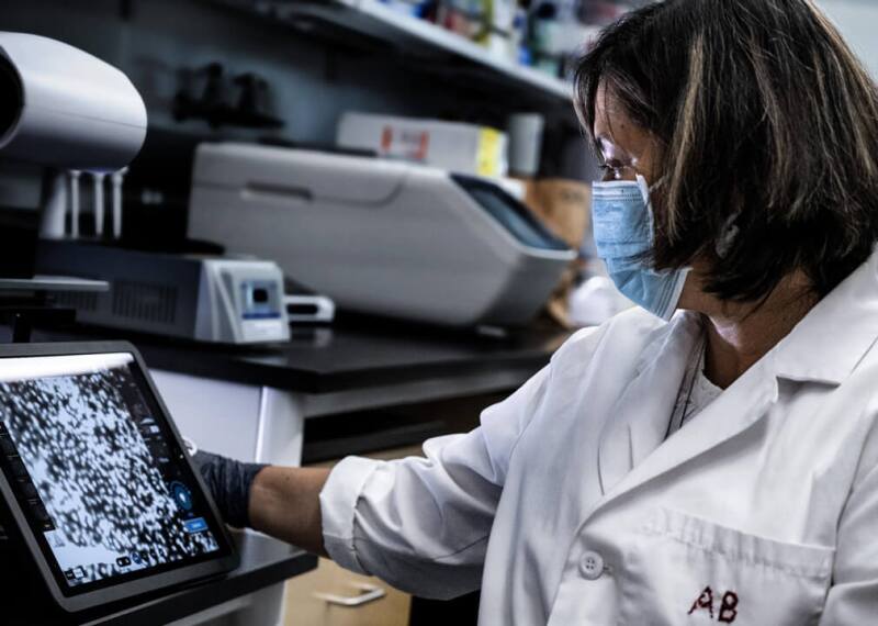 Female lab technician looking at microscope output