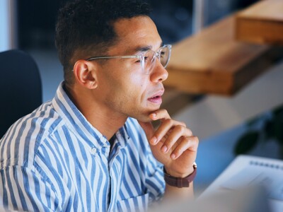 Professional is focused and thinking while working at his computer