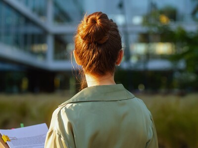 Accountant with a stack of papers in front of an eco friendly office building