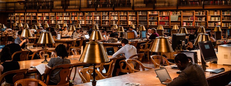 Students study at long table in a law library.