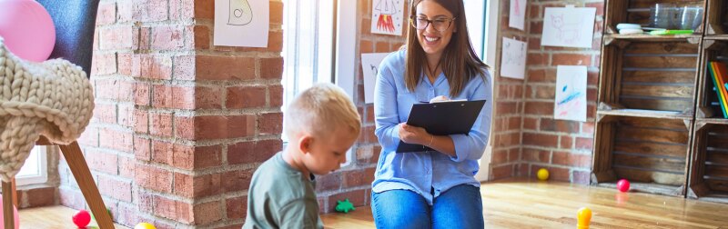 Female social work researcher observes a young boy's social behavior.