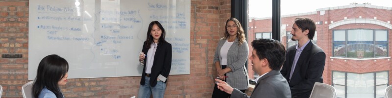A group of Medill students conduct a product lifecycle work session on the white board