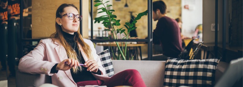 businesswoman working on her MBA goals essay at coffee shop