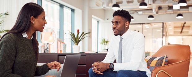Two professionals holding an informal meeting in office lobby
