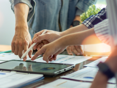 people standing around tablet discussing a product