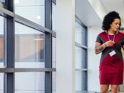 Two teachers walking through a hallway, discussing policies