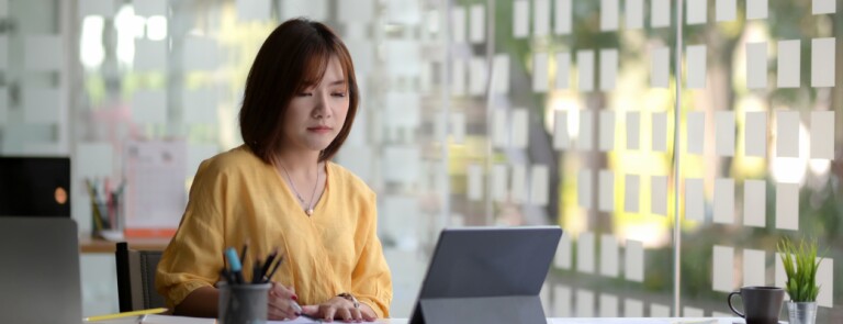 Woman sits in an office by the window