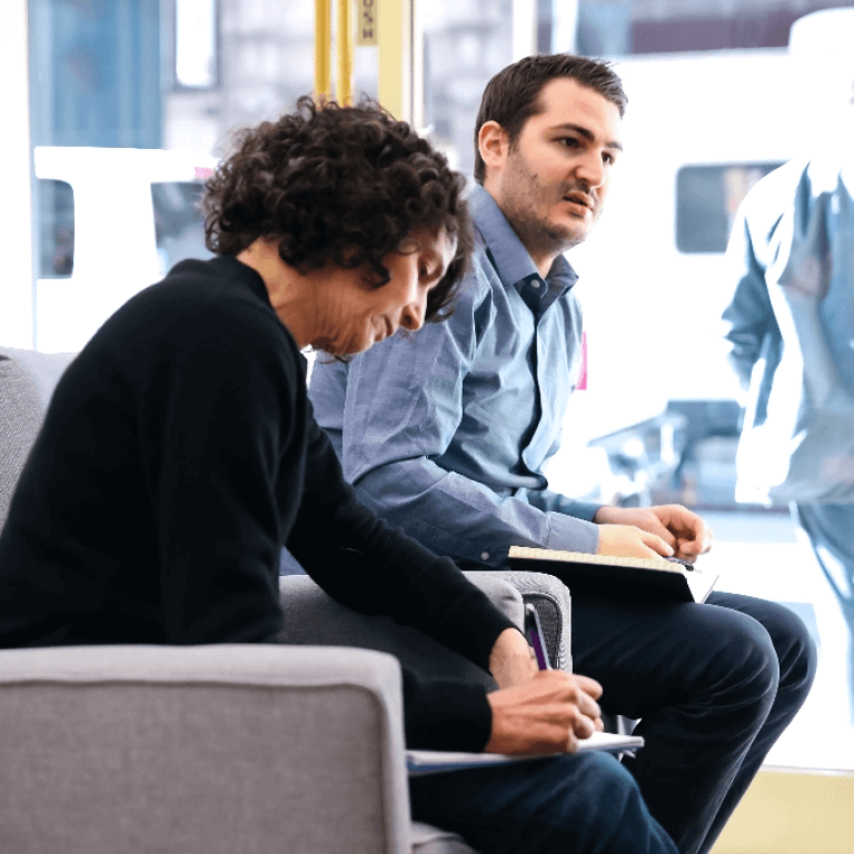 Man and woman talking and taking notes