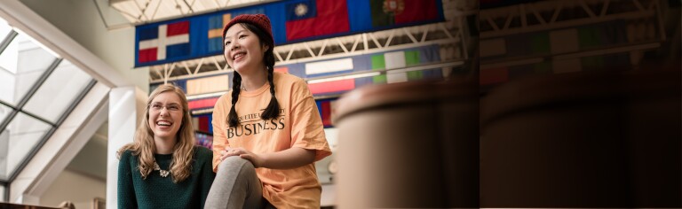 Marquette students laughing in front of international flags