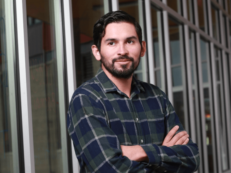 Man with arms crossed in plaid shirt