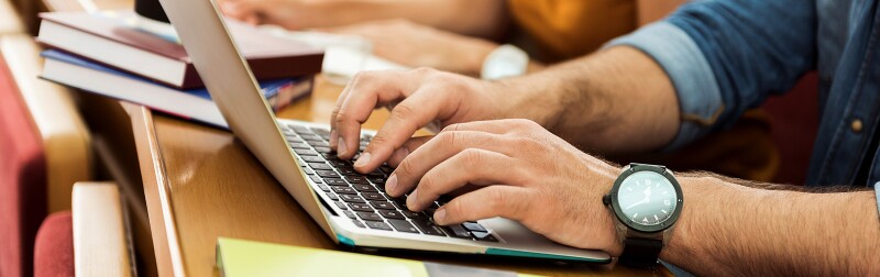 Young man in class working on his laptop