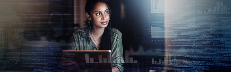 Woman thinking at a laptop with computer data as an overlay