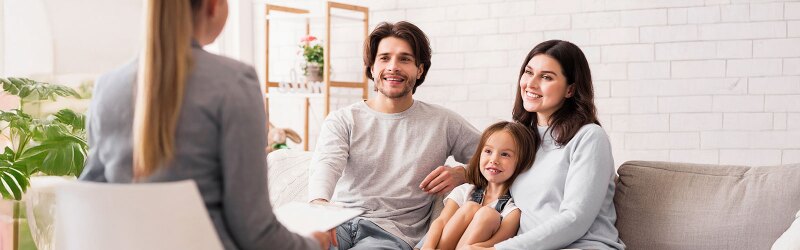 Two parents and a child interacting with a counselor