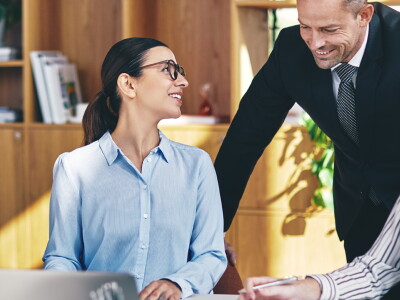 A team of accountants dressed in business attire are gathered at a table, smiling at each other.