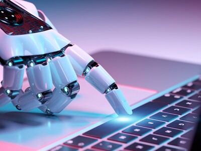 Robotic hand pressing a keyboard on a laptop