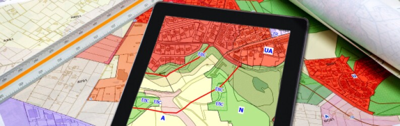 Maps and a tablet screen showing urban and rural landscapes