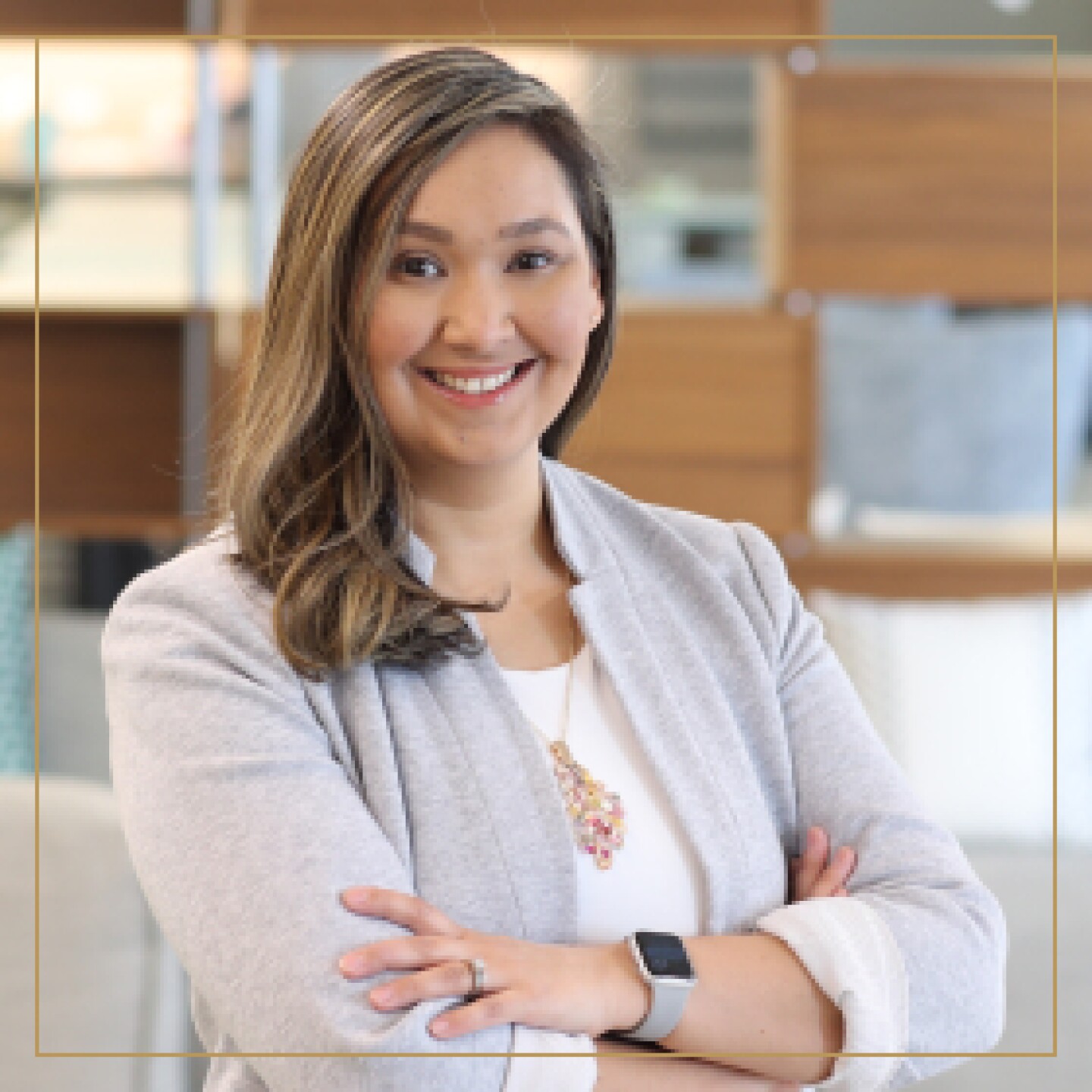 Woman smiling in gray blazer and white shirt