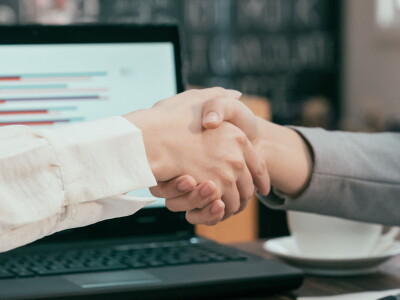 Close-up shot of two women shaking hands.