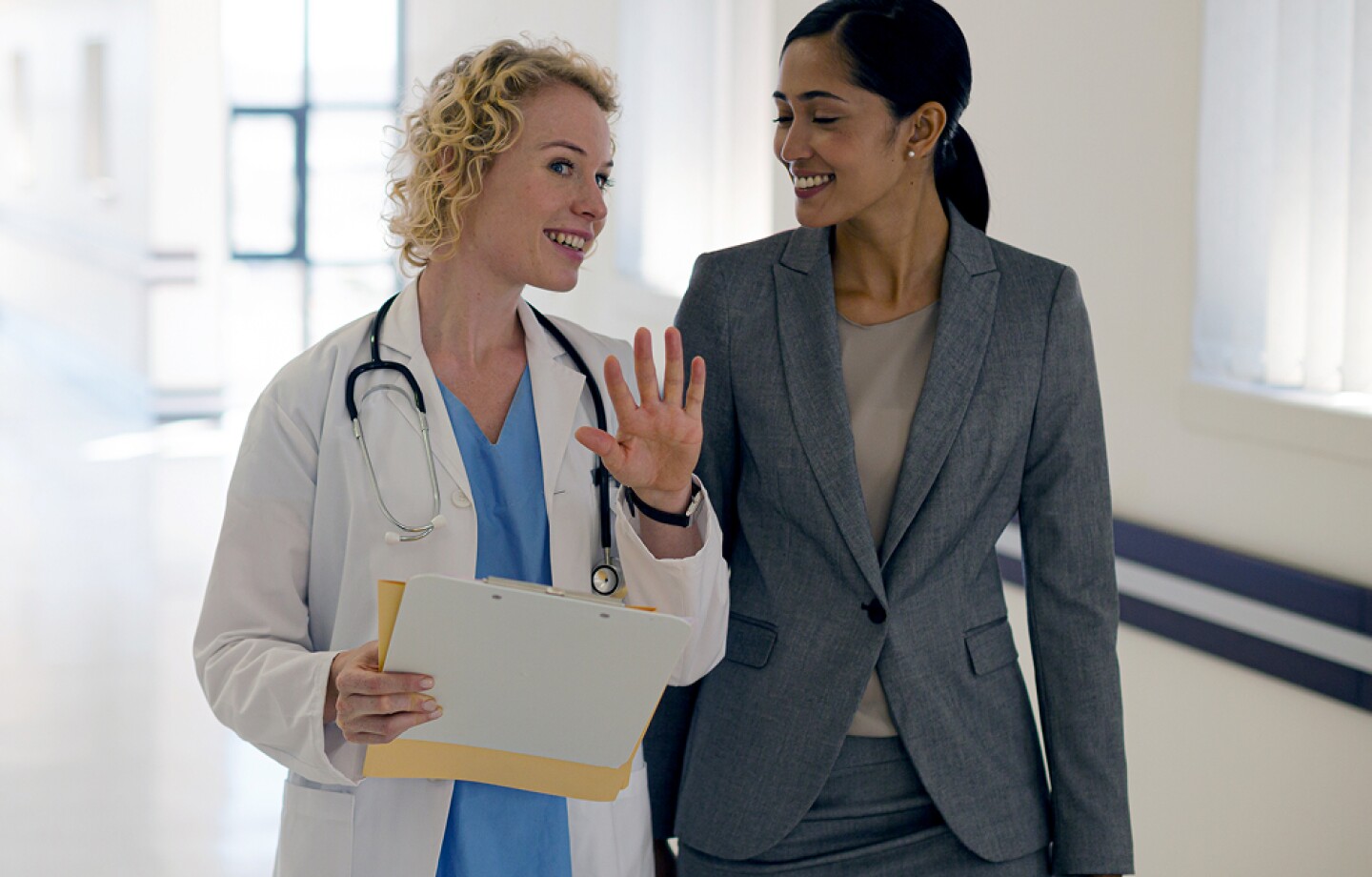 Doctor and administrator walking in hospital corridor