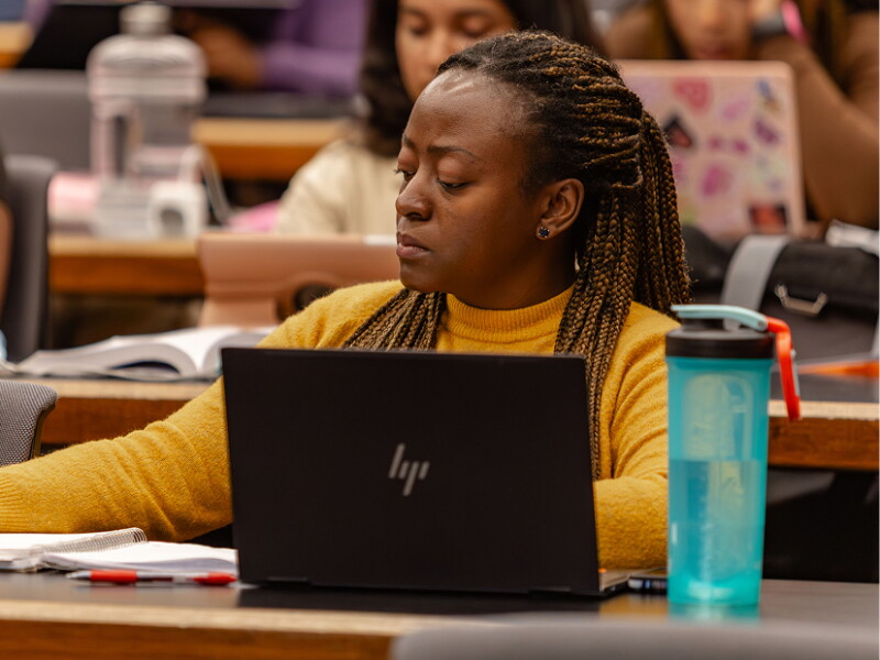 Woman taking notes in class.