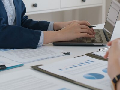 Two professionals reviewing financial charts and documents on wealth management during a business meeting.