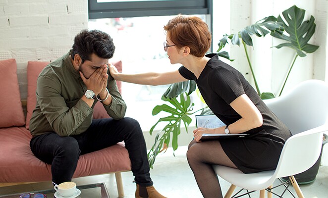 Social worker comforting upset man
